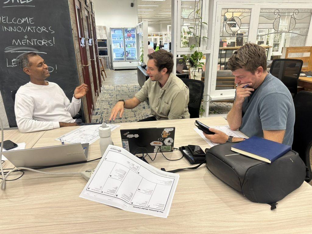 Founders and a mentor working through a Business Model Canvas