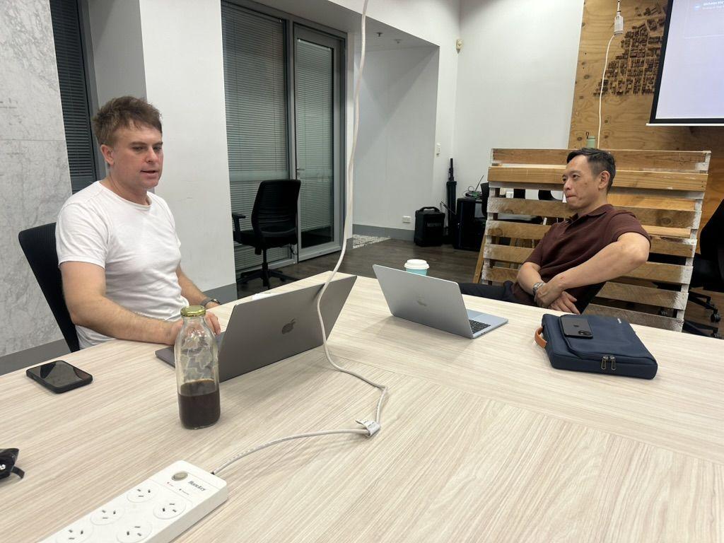 Two people working side by side on laptops