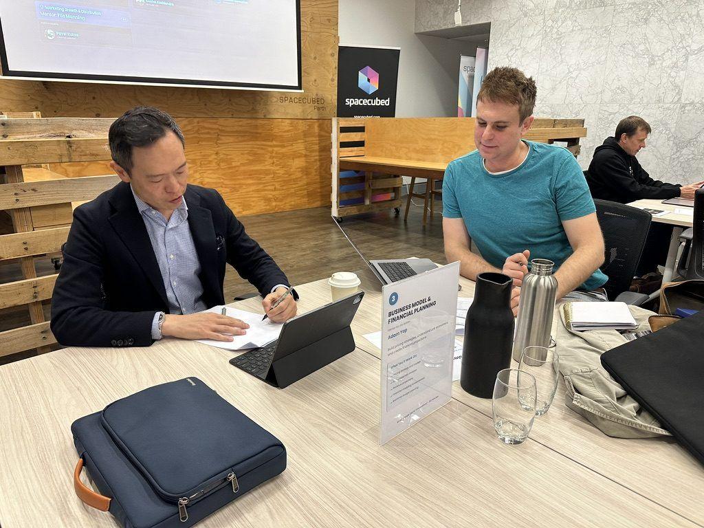 A mentor working with a founder at the Business Model and Financial Planning station