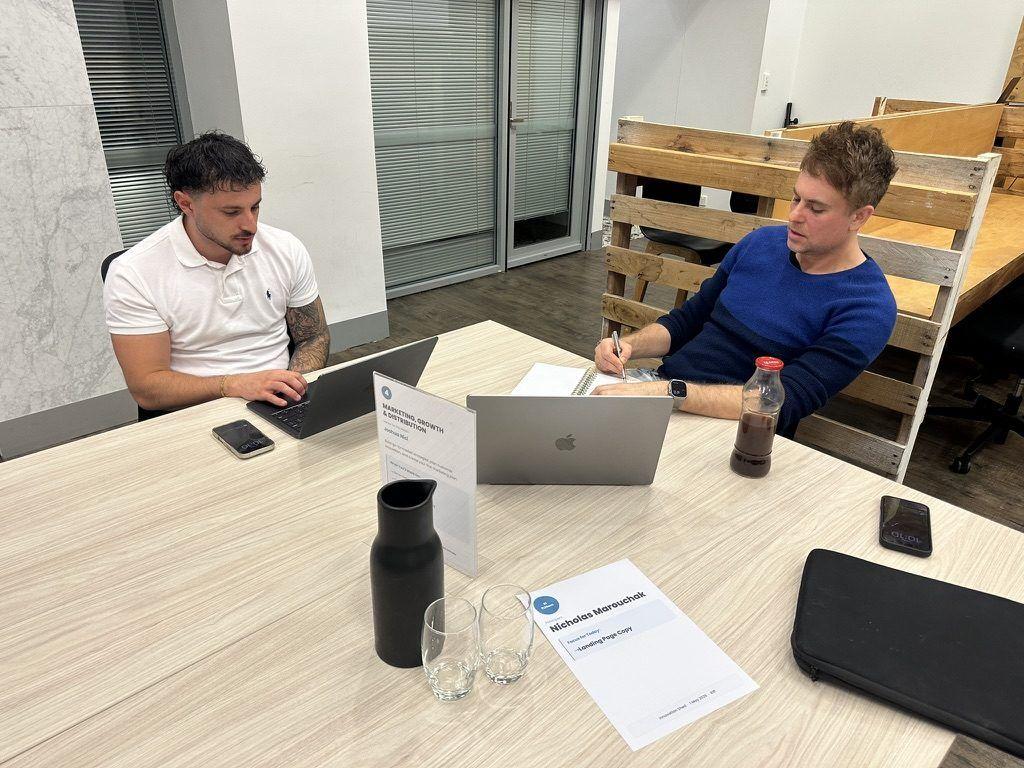 Two people working at the Marketing, Growth and Distribution station